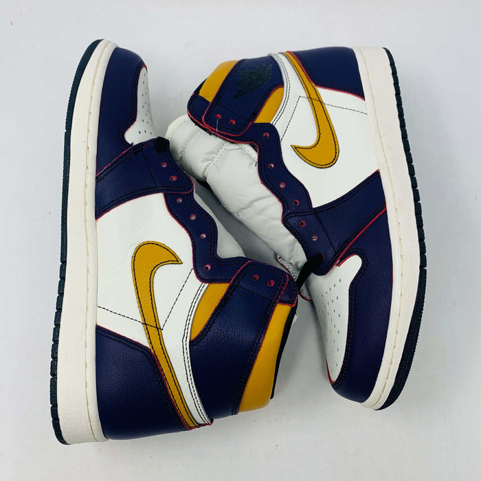 A brand new Jordan 1 High SB LA to Chi sneaker rests on a black Jordan box with a red logo. This authentic high-top shoe features multi-colored accents of purple, yellow, white, and red, with the label proudly reading 1985 Air Jordan 1.