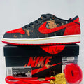 Jordan 1 Low OG Chinese New Year sneaker in black and red with dragon design, extra laces and tassels, displayed on Nike box.