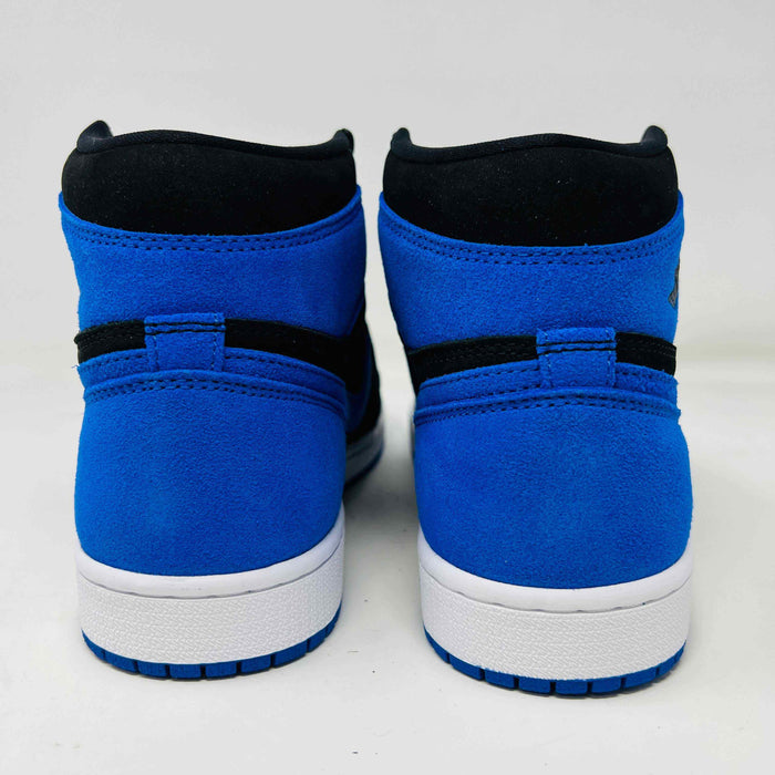A pair of new Jordan 1 Retro High OG Royal Reimagined sneakers by Jordan rests on a matching box. These genuine shoes have blue accents on the swoosh, heel, and toe cap with a white midsole. The box also features a blue Nike logo.