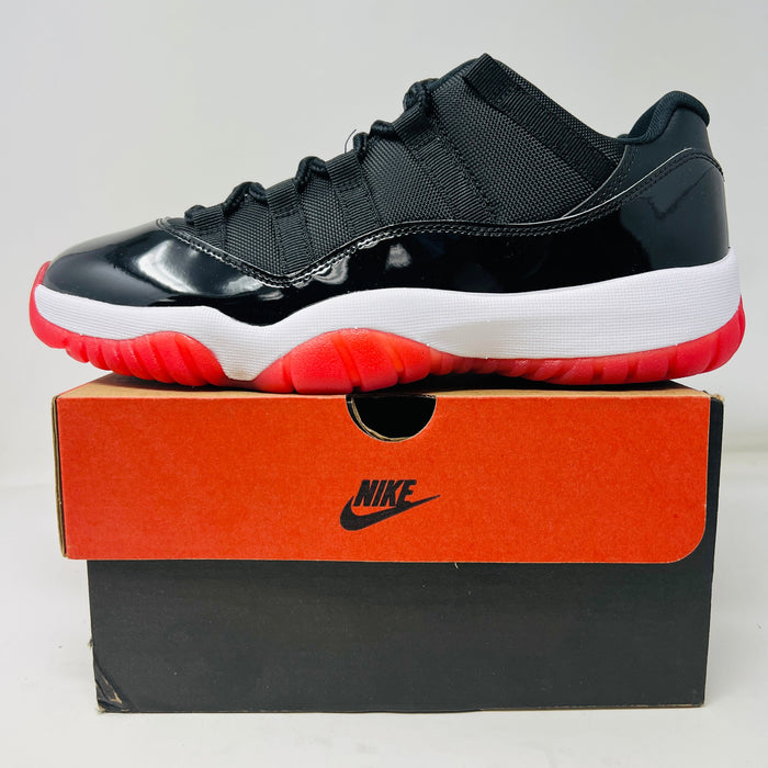 Jordan 11 Retro Low Bred sneaker in black, white, and red on Nike box, 2025 model, brand new condition