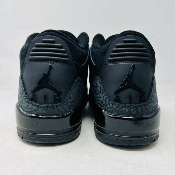 The Jordan 3 Retro Black Cat (2025) sneaker, featuring a glossy finish and elephant print accents, sits on a black box with the red Jumpman logo. This brand new, 100% authentic release from Jordan ensures style and exclusivity.