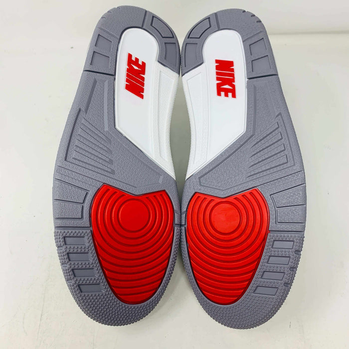 The Jordan 3 Retro OG Black Cement (2024) sneaker, featuring black and gray tones with red accents, is displayed on a sleek black shoebox. With textured details and visible air cushioning, an orange Nike Air tag authenticates this stylish addition to your collection.