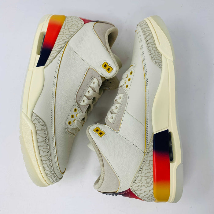 The Jordan 3 Retro SP J Balvin Medellín Sunset sneakers by Jordan feature a stylish white and beige design with textured toe and heel areas. The midsole is adorned with a vibrant gradient of red, orange, and dark blue against a plain white background.