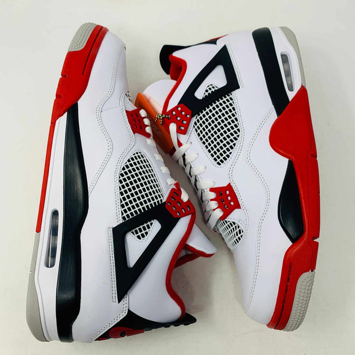 The Jordan 4 Fire Red sneaker in white, red, and black is brand new and authentic, featuring mesh details, a visible air unit in the sole, and a Nike Air tag on the laces. It comes in a box with a speckled gray design and red Nike Air logo.