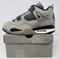 Jordan 4 Retro Cave Stone sneaker in light gray with black accents on box, 2025 model