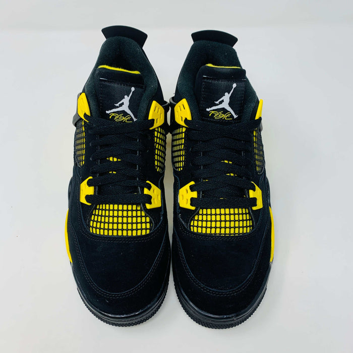 Jordan 4 Retro Thunder 2023 GS sneakers displayed on a box.