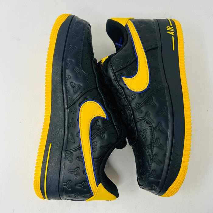 The new black Nike Air Force 1 Low Kobe Bryant Lakers Away sneakers have yellow accents like a swoosh and sole, sitting on a white box with the Nike logo and icon. These 100% authentic shoes are available as a final sale item.