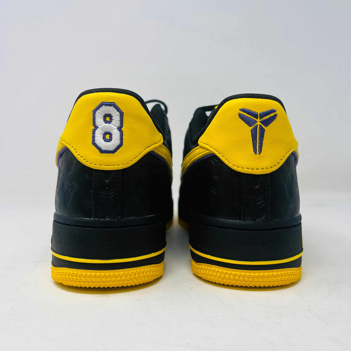 Brand new Nike Air Force 1 Low Kobe Bryant Lakers Away sneaker in black with yellow and blue accents, featuring embossed details. Displayed on a white box with a yellow Nike logo and Kobe Bryant symbol. Limited edition of 8000, ideal for those seeking standout accessories.