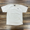 Preowned Hellstar Basic T-Shirt white crew neck with small logo on chest laid flat on wooden floor