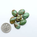 Hubei Cloud Mountain Turquoise cabochons, blue and green color with black matrix, polished stones on a white background with a US dime for scale