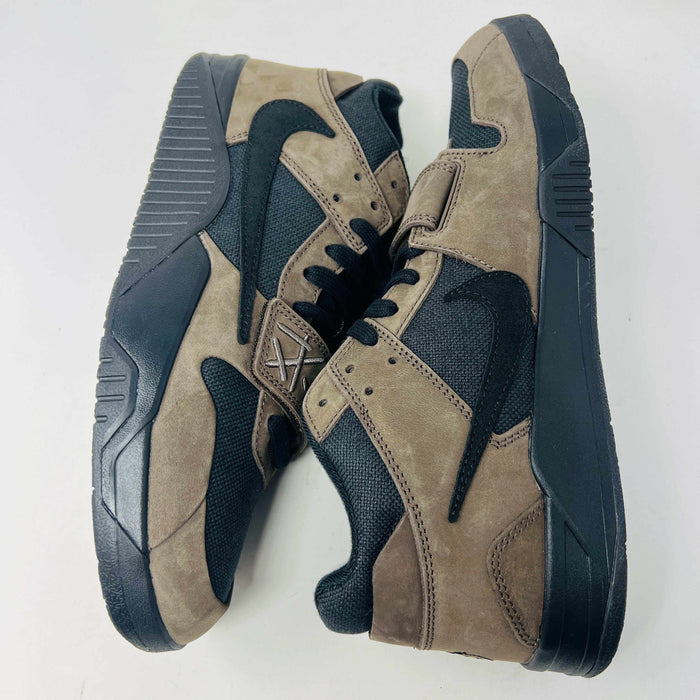 A pair of Jordan Jumpman Jack TR Travis Scott Dark Mocha sneakers are showcased on a brown box labeled JACK in white. The brown and black sneaker features a black swoosh, laces, and textured sole. Its 100% authentic with extra laces and bag, set against a plain white background.