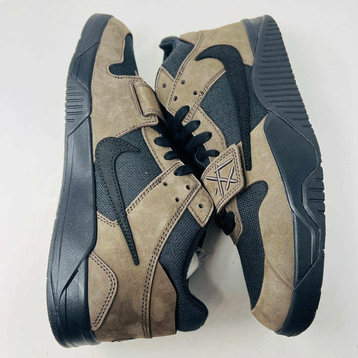 A pair of Jordan Jumpman Jack TR Travis Scott Dark Mocha sneakers are showcased on a brown box labeled JACK in white. The brown and black sneaker features a black swoosh, laces, and textured sole. Its 100% authentic with extra laces and bag, set against a plain white background.