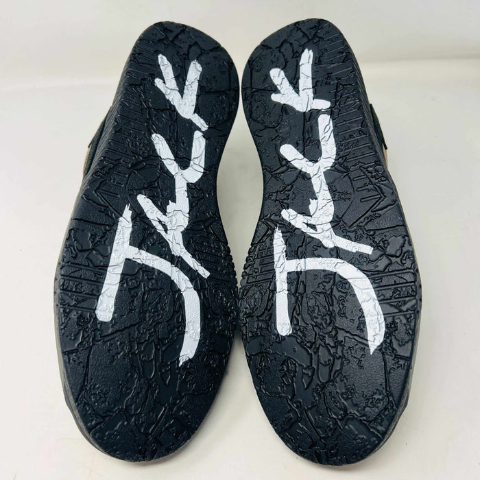 A pair of Jordan Jumpman Jack TR Travis Scott Dark Mocha sneakers are showcased on a brown box labeled JACK in white. The brown and black sneaker features a black swoosh, laces, and textured sole. Its 100% authentic with extra laces and bag, set against a plain white background.