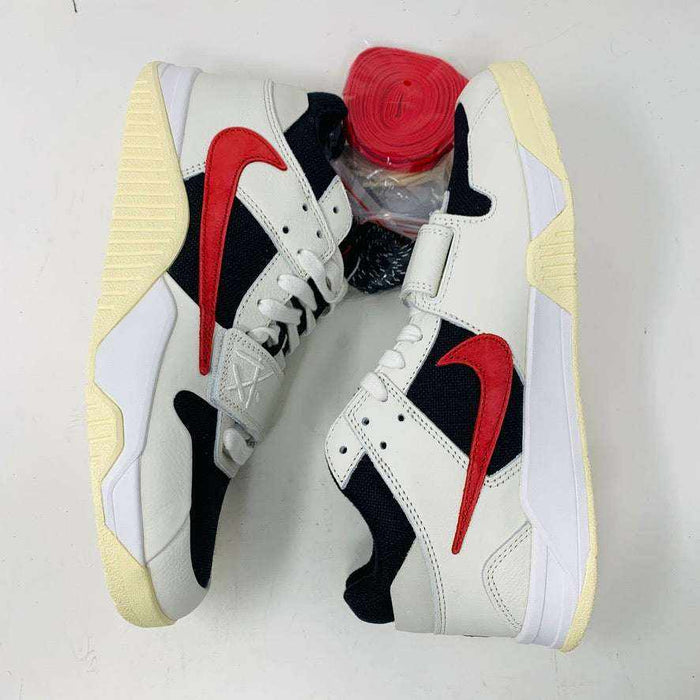 Authentic Jordan Jumpman Jack TR Travis Scott University Red shoes with white and black uppers feature red swoosh logos, resting sideways on a white surface. The soles have a slightly yellowed hue. Brand new red shoelaces are packaged in plastic, placed between the shoes, ready to complete this 2024 style statement.