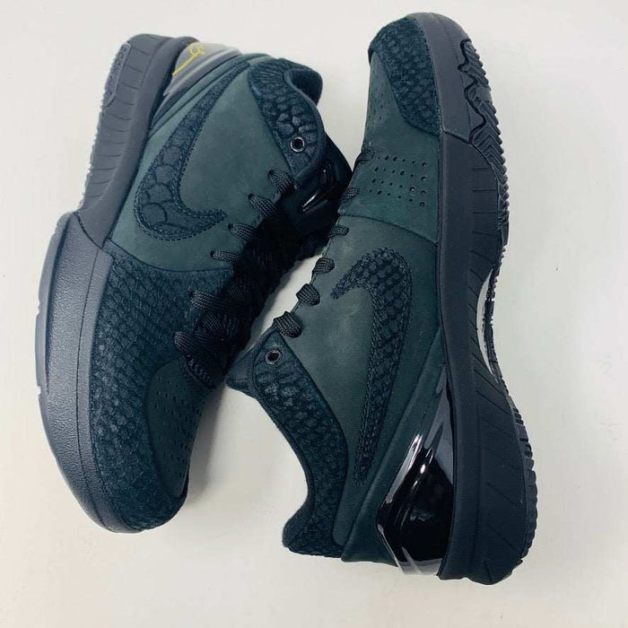 A brand new Nike Kobe 4 Protro Gift of Mamba sneaker in black, featuring a textured design with glossy and matte elements and prominent swoosh logo, is showcased atop its matching shoebox. Distinct patterns on the side and heel capture the essence of 2023s authentic shoe style.