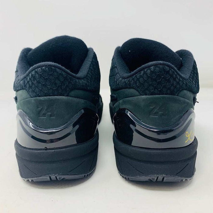 A brand new Nike Kobe 4 Protro Gift of Mamba sneaker in black, featuring a textured design with glossy and matte elements and prominent swoosh logo, is showcased atop its matching shoebox. Distinct patterns on the side and heel capture the essence of 2023s authentic shoe style.