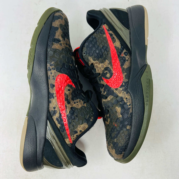 Close-up of a Nike Kobe 6 Protro Italian Camo (2024) (GS) shoe in black and dark olive with a red swoosh, resting on an orange Nike box. The 100% authentic shoe features a textured upper shown from the side, highlighting its design and striking color contrast.