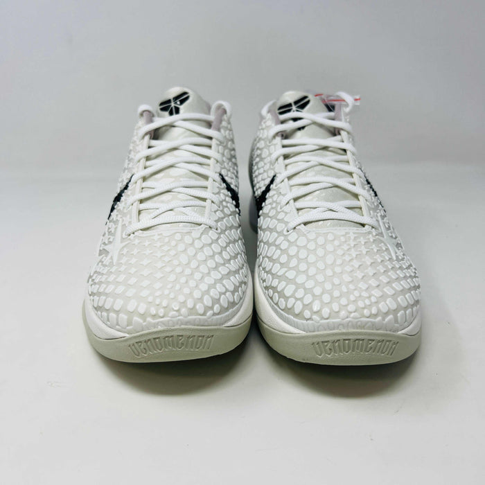 The Nike Kobe 6 Protro Sail All-Star shoes, featuring white textured patterns and black swoosh details with star designs, are elegantly displayed on a sleek black shoebox.