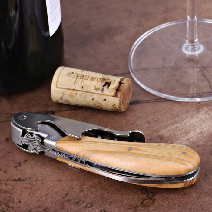 Laguiole Magnum Corkscrew, close-up of olive wood handle with decorative woodcock and stainless steel.