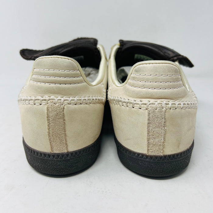 The 2023 adidas Samba Wales Bonner Ecrtin Brown sneakers feature beige uppers with three yellow stripes, a brown logo flap, and black soles. Despite general wear, the side and tongue branding stays distinct. Theyre displayed side by side on a white background.