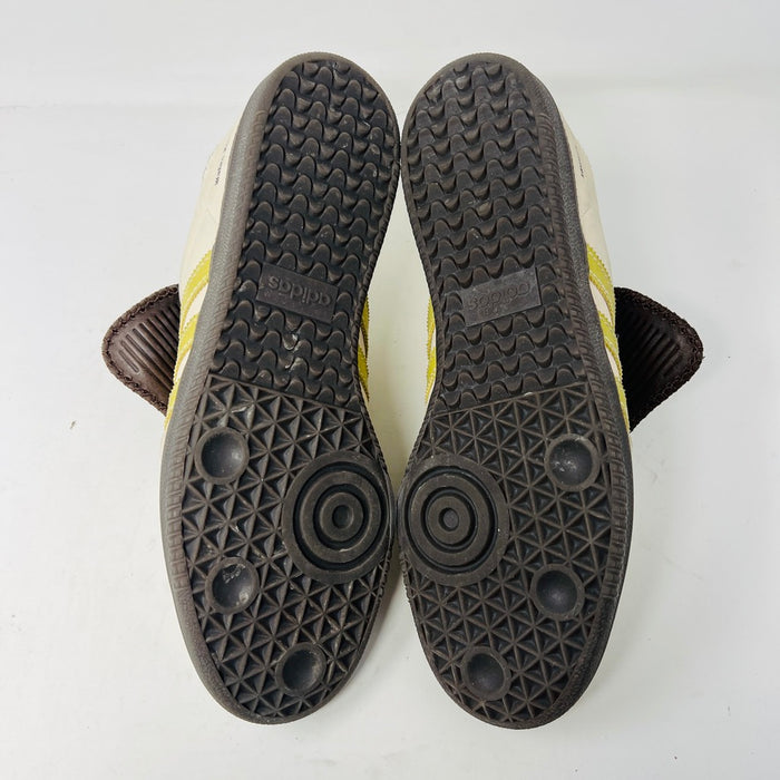 The 2023 adidas Samba Wales Bonner Ecrtin Brown sneakers feature beige uppers with three yellow stripes, a brown logo flap, and black soles. Despite general wear, the side and tongue branding stays distinct. Theyre displayed side by side on a white background.