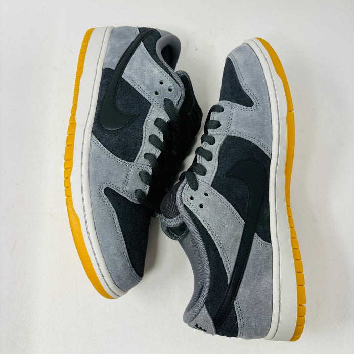 Introducing the Nike SB Dunk Low Dark Smoke Grey sneakers, featuring a gray and black design with a mustard sole. Packaged in a signature purple box with extra black laces, these 100% authentic sneakers ensure your style stays fresh and versatile.