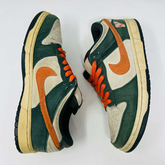 The Nike SB Dunk Low Eire by Holy Ground features a green and beige colorway with an orange swoosh and logo detail on the heel. It comes with a black box, extra Nike laces, ensuring authenticity and versatility.