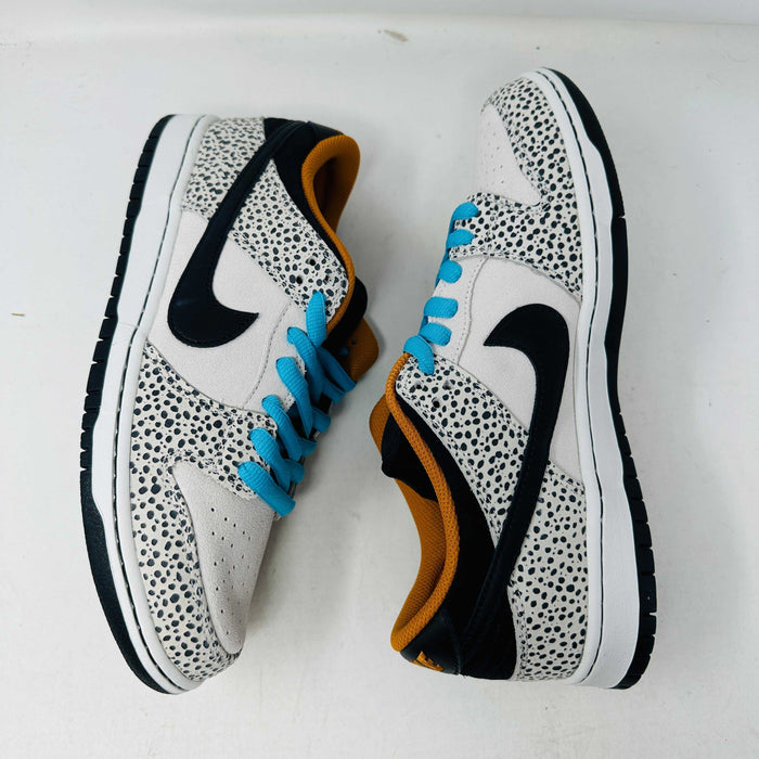 The Nike SB Dunk Low Electric Pack Olympic Safari, a new 2024 release, showcases a speckled gray and white design with a black swoosh, blue laces, and orange lining, elegantly set upon its box against a plain backdrop.