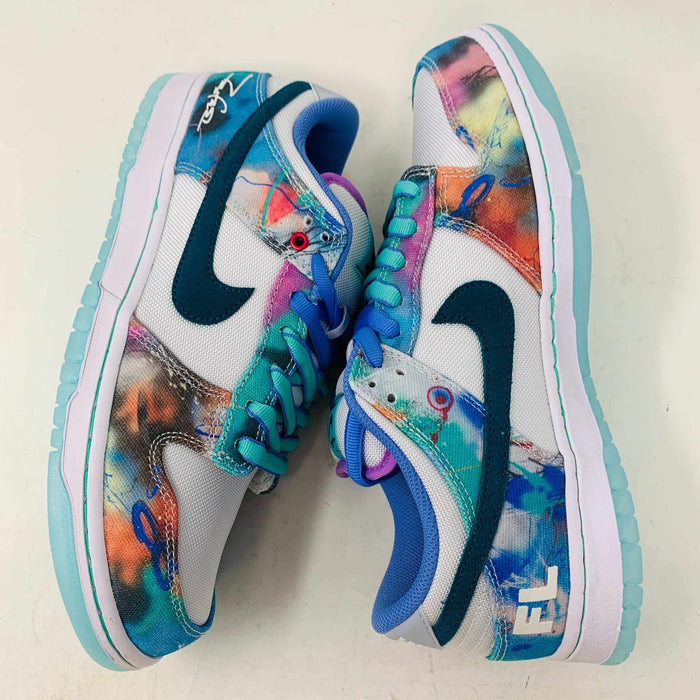 The Nike SB Dunk Low Futura Laboratories Bleached Aqua sneakers showcase a vibrant abstract design in blue, pink, orange, and turquoise. Teal swooshes and light blue soles complement the purple laces and FL branding on a pristine white surface.