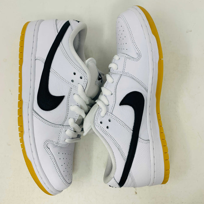 A brand new Nike SB Dunk Low in white with a black swoosh, white laces, and a gum sole rests on a 2023 purple Nike SB shoebox featuring bold white text. The profile view showcases its authentic design.