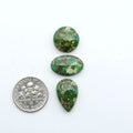 Sonoran Mountain Turquoise cabochons, blue-green color with natural matrix, polished stones on a white background, with a US dime for scale
