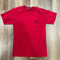 Preowned red Stussy Designs tee with back logo on wooden floor