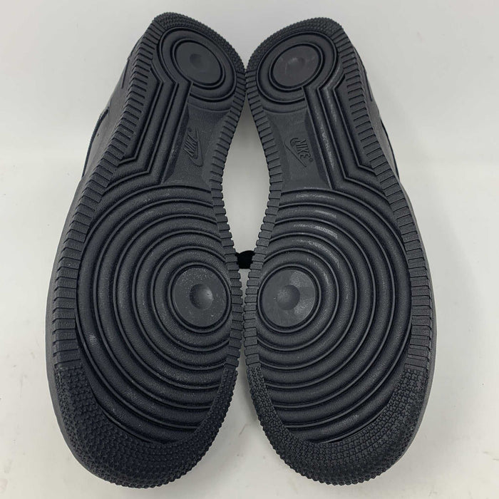 The Nike Supreme Air Force 1 Black features a perforated design on the toe box, black supreme laces with a shiny tag, and a prominent Nike logo, all set against a plain white background.
