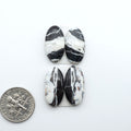 White Buffalo stone cabochons, white stone with black matrix, polished stones on a white background, with a US dime for scale