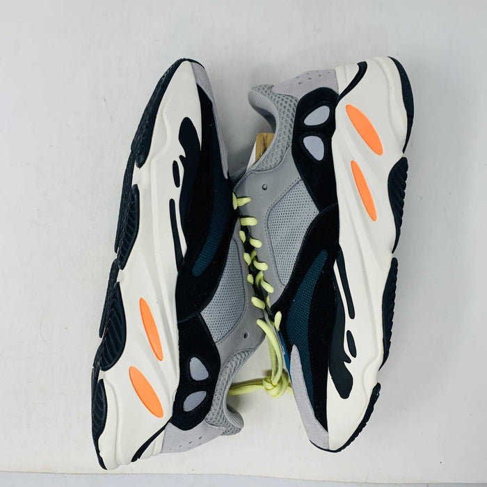 A Yeezy 700 Waverunner with a multicolor scheme of gray, black, teal, and orange rests on a Yeezy Boost 700 Made by Adidas box. Sales are final on these authentic shoes.